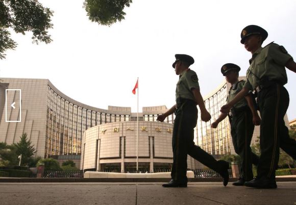 Chinese soldiers march past the People's Bank of China